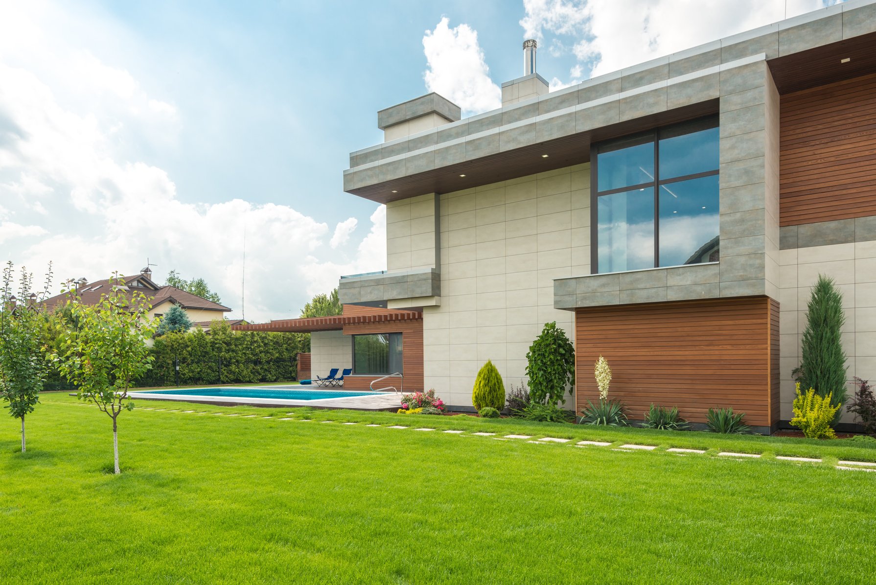 A Beautiful House with Swimming Pool Near the Garden with Green Grass