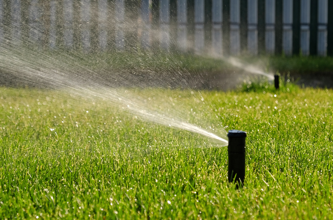 Automatic garden irrigation system watering lawn. Savings of water from sprinkler irrigation system with adjustable head. Automatic equipment for irrigation and maintenance of lawns, gardening.